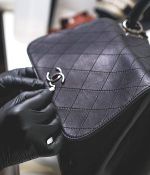 Renowacja torebki Chanel, na zdjęciu widoczny jest proces profesjonalnej renowacji torebki Chanel, czarna torebka w trakcie czyszczenia i przygotowania do renowacji powierzchni